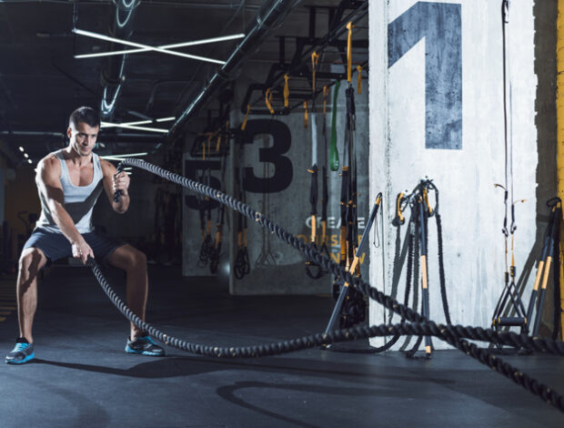 young-man-exercising-with-battle-ropes_23-2147949559